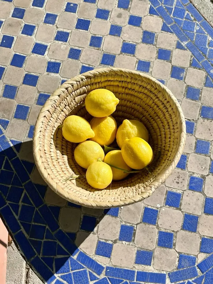 Panier en osier rempli de citrons sur une mosaïque marocaine bleue
